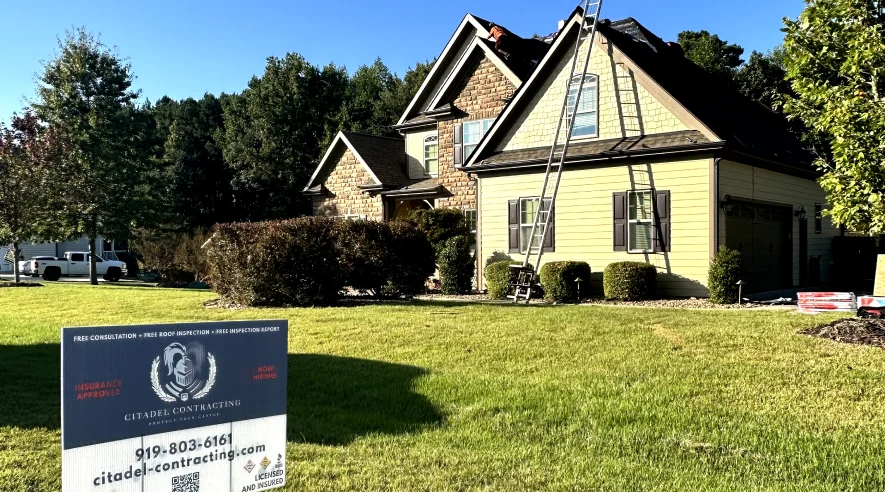 Citadel Contracting yard sign on the lawn of a yellow two-story home