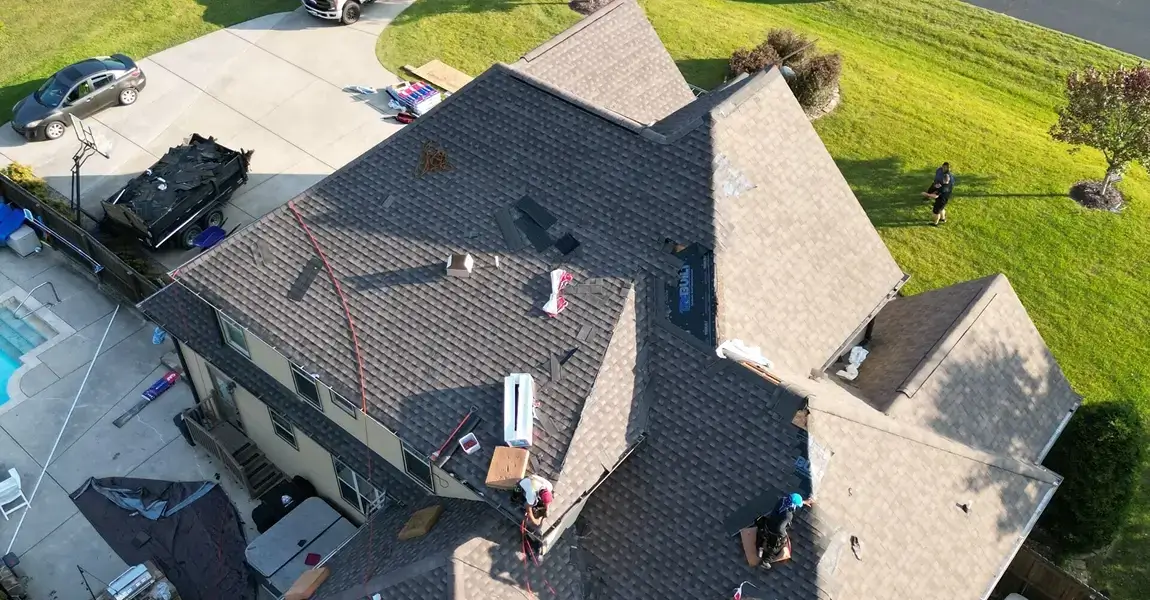 Drone view of a multi-gable roof beside a backyard pool